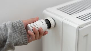 Hand an einem Heizungsthermostat, Foto: Colourbox