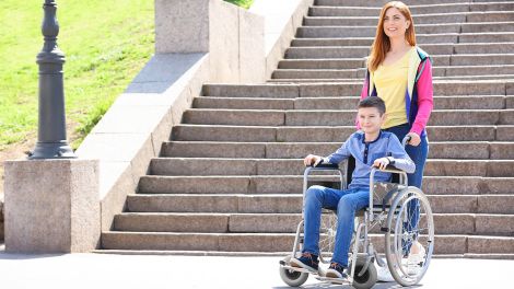 Ein Kind im Rollstuhl mit seiner Mutter, Bild: imago-images