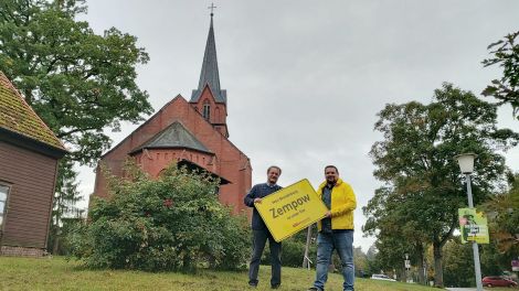 Antenne-Reporter Björn Haase-Wendt übergibt unsere Ortstafel an den Zempower Ortsvorsteher Ulrich Schnauder, Bild: Antenne Brandenburg / Alexander Heisig