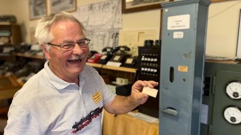 Heinz Welisch zeigt, wie man sich eine Fahrkarte früher am Automaten holte, noch heute kann man im Eisenbahnmuseum eine Karte lösen, Bild: Antenne Brandenburg/Anke Blumenthal