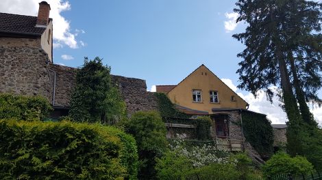 Leben an und mit der Stadtmauer. Teile des gewaltigen Bauwerkes gibt es bis heute. Manche Wohnhäuser wurden direkt daran gebaut, Foto: Antenne Brandenburg, Eva Kirchner-Rätsch