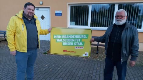 Schildübergabe in Walsleben von Antenne-Reporter Björn Haase-Wendt an Bürgermeister Burghard Gammelin, Foto: Antenne Brandenburg/Alexander Heisig