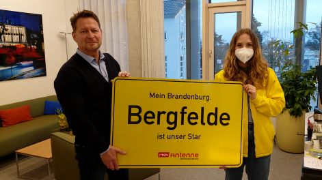 Antenne-Reporterin Marie Günther besucht Steffen Apelt, Bürgermeister von Hohen Neuendorf, und überreicht das Ortsschild für den Ortsteil Bergfelde,Bild: Antenne Brandenburg/A.Heisig