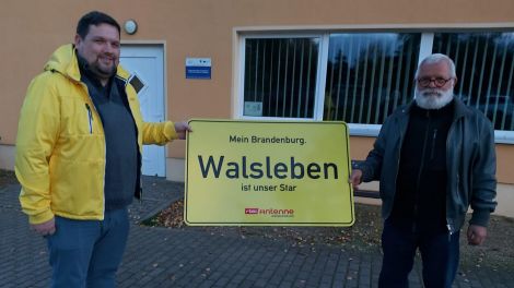 Schildübergabe in Walsleben von Antenne-Reporter Björn Haase-Wendt an Bürgermeister Burghard Gammelin, Foto: Antenne Brandenburg/Alexander Heisig
