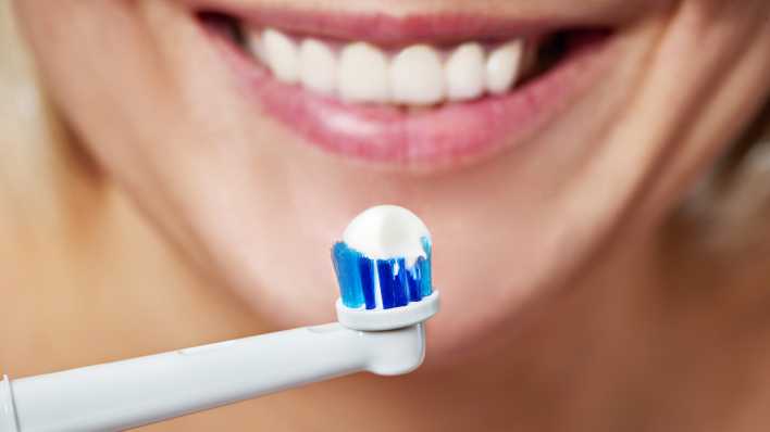 Frau putzt Zähne mit elektrischer Zahnbürste, Foto: Colourbox