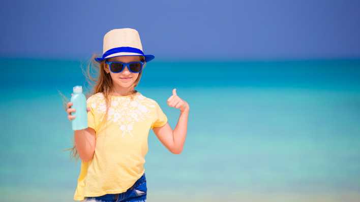 Mädchen am Strand mit Sonnencreme, Foto: Colourbox